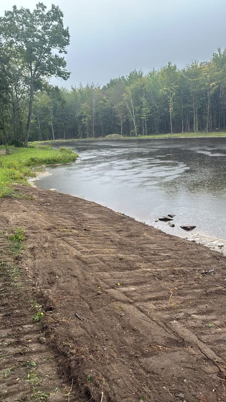 Freshly graded pond shoreline and site work completed by REM Earthworks in Southern Maine