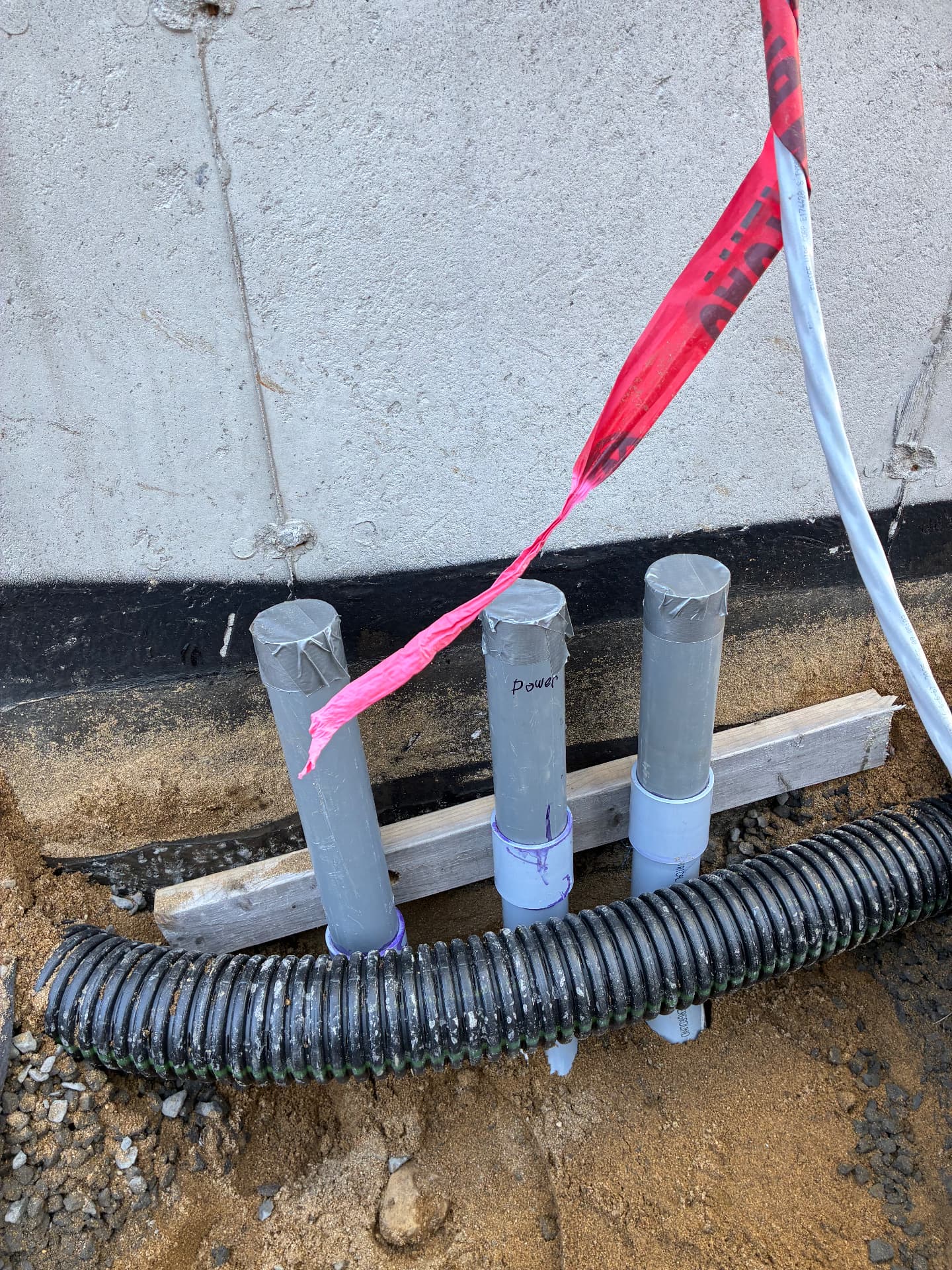 Conduit stubs and drain pipe brought up to a new home foundation